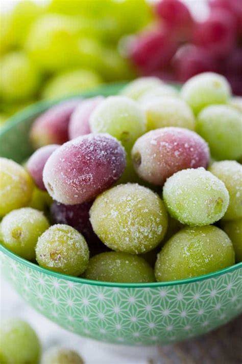A bowl contains frozen grapes and fresh strawberries as a sweet low-calorie snack.