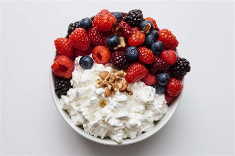 A small bowl of cottage cheese with berries is portioned as an evening snack.